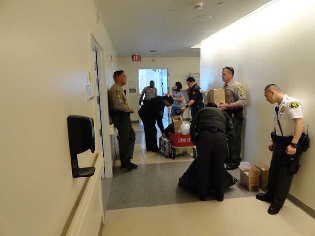 Picture of Sheriff's personnel with Securitas Personnel in Hallway in Pediatric Unit getting Toys Ready.