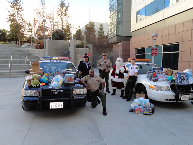 Picture of Sheriff's Personnel with Santa by Patrol Car with Toys on Hood