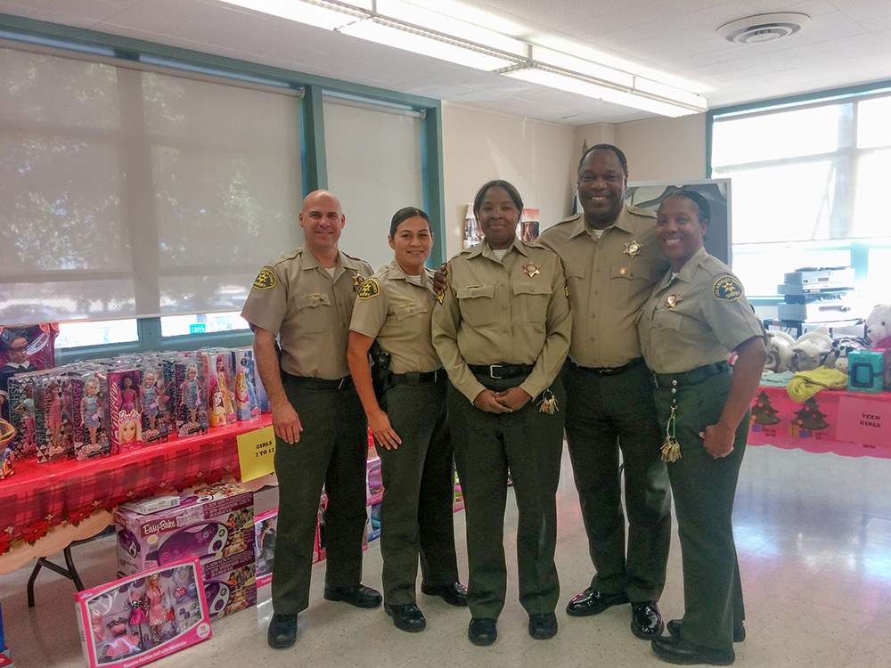 Sheriff's personnel hosting a holiday party for children